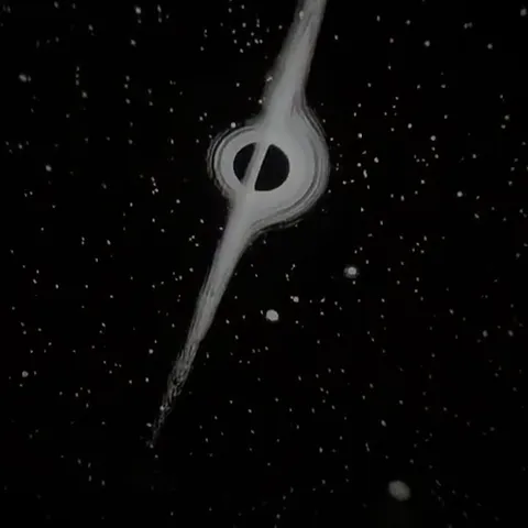 Still from the seller's video: a black hole with a bright ring and a long jet of light, scattered stars around it.